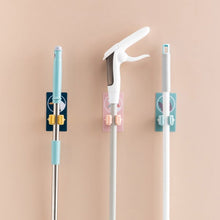 Self-adhesive mop and broom organizer for space-saving storage.